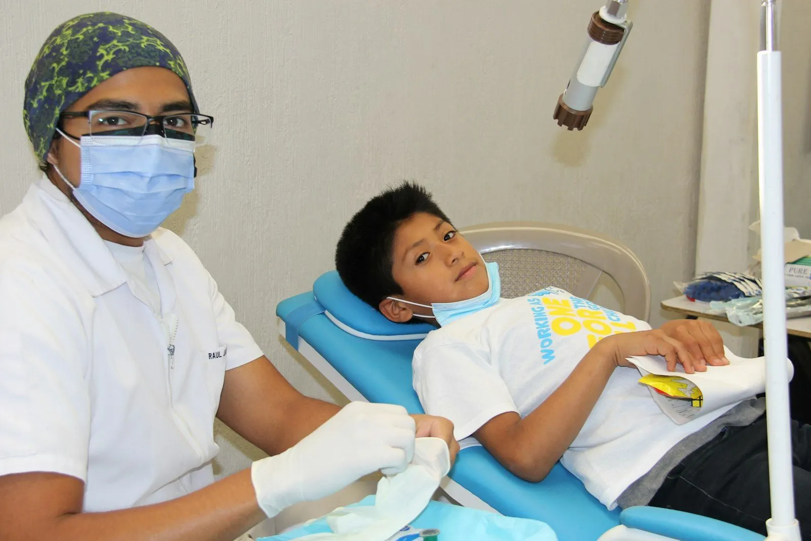 Niño en la consulta dental acompañado por la odontóloga